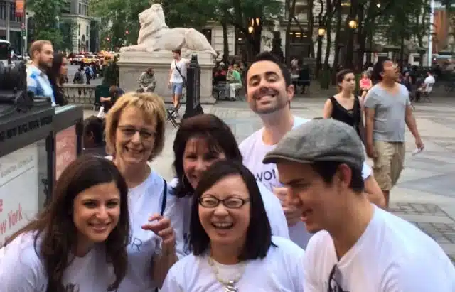 Team gets a selfie in front of a lion sculpture in NYC.