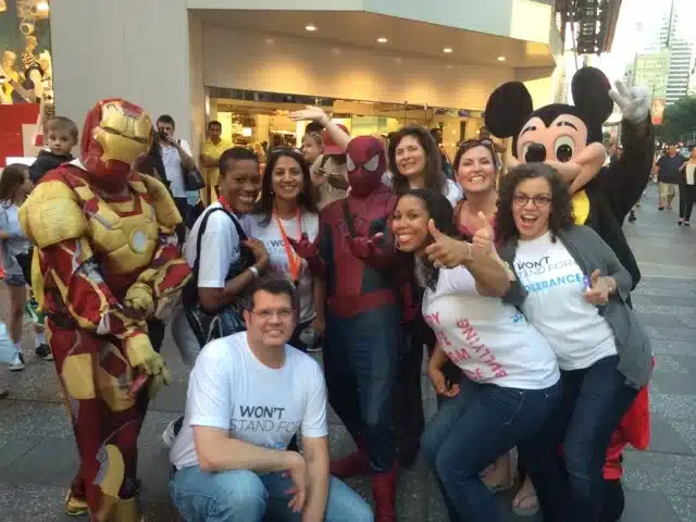 Team poses with Disney characters during Midtown scavenger hunt.