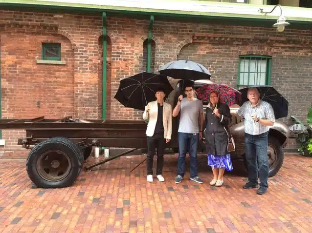 Toronto Distillery District Team Building Scavenger Hunt Scavenger hunt team with umbrellas at Toronto's Distillery District.
