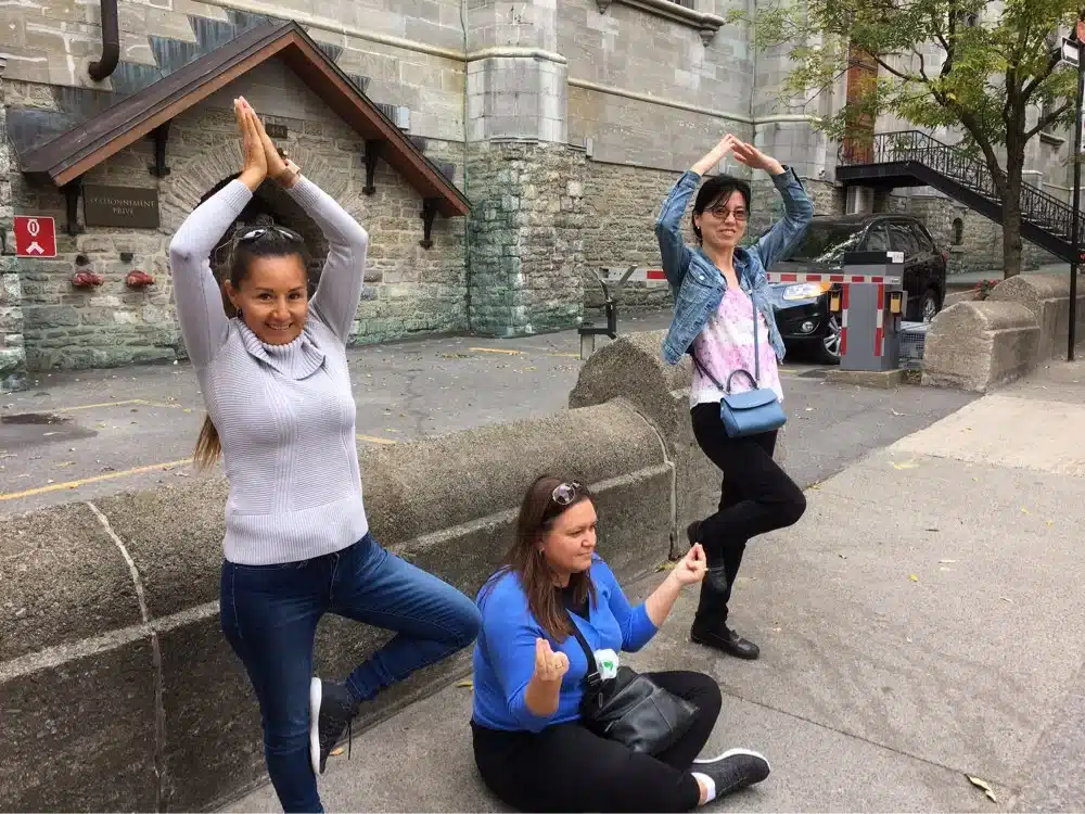 3 people doing yoga poses in Old Montreal.