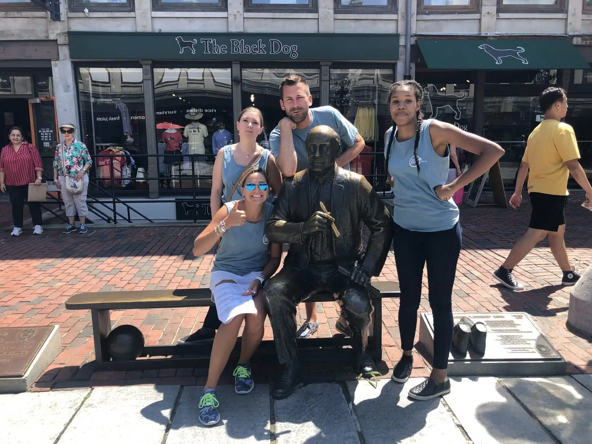 Four people on a corporate team building scavenger hunt post with a statue in Boston