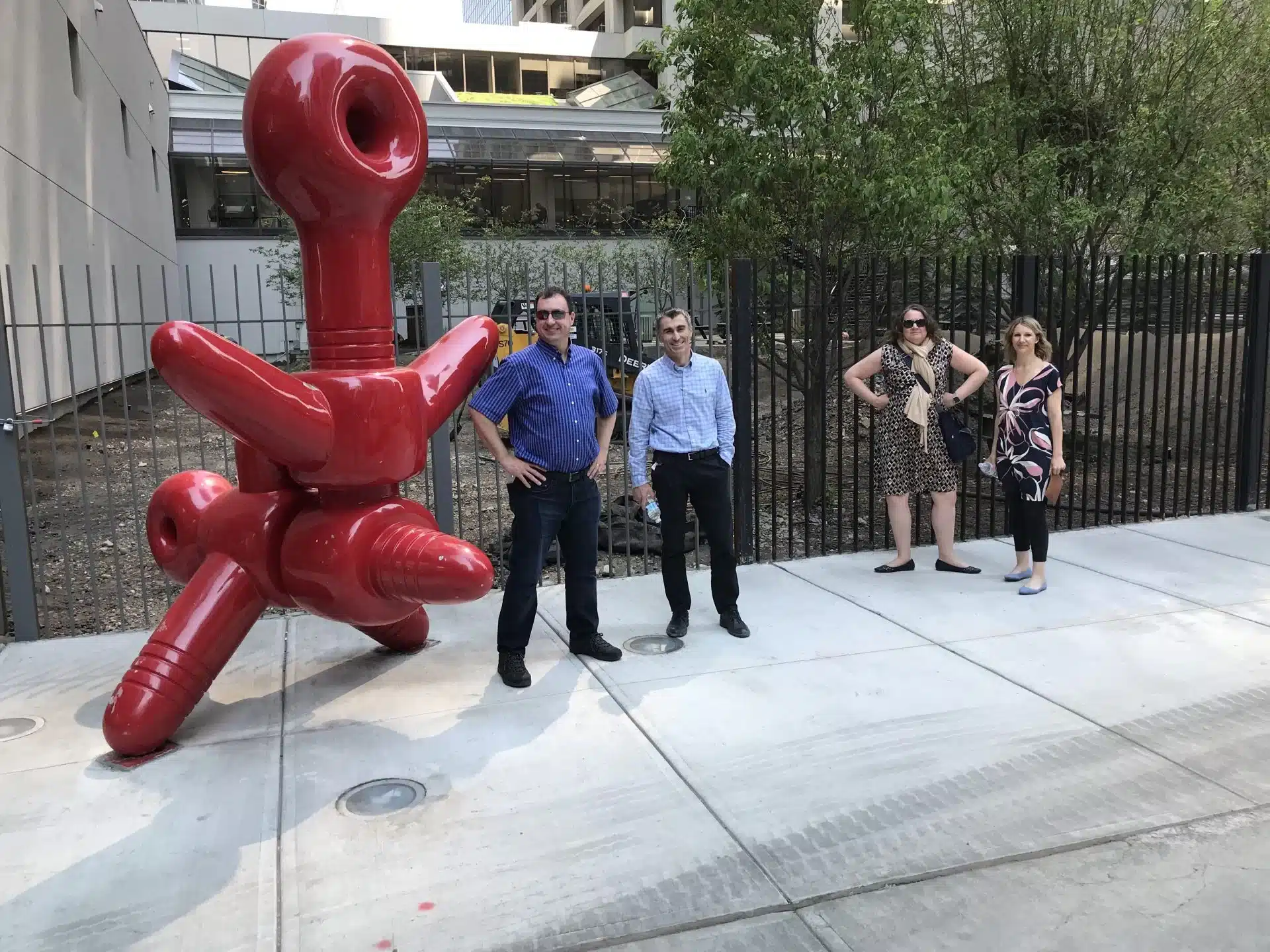 Scavenger hunt team posing with red sculpture in downtown Calgary