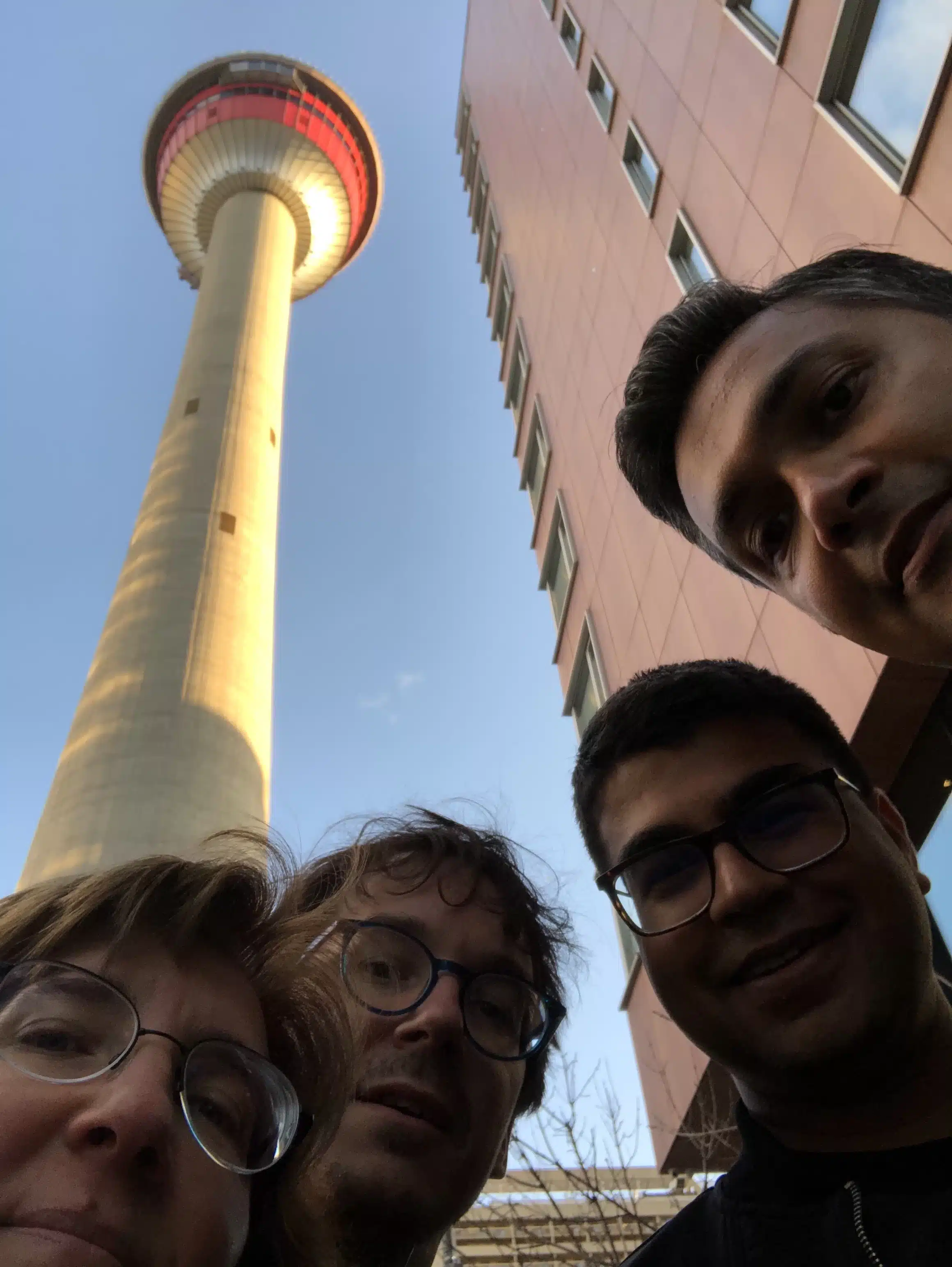 Scavenger hunt team leaning and looking down with Calgary Tower in the background
