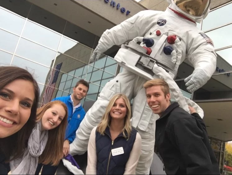 Corporate scavenger hunt team poses with an astronaut in Grand Rapids.