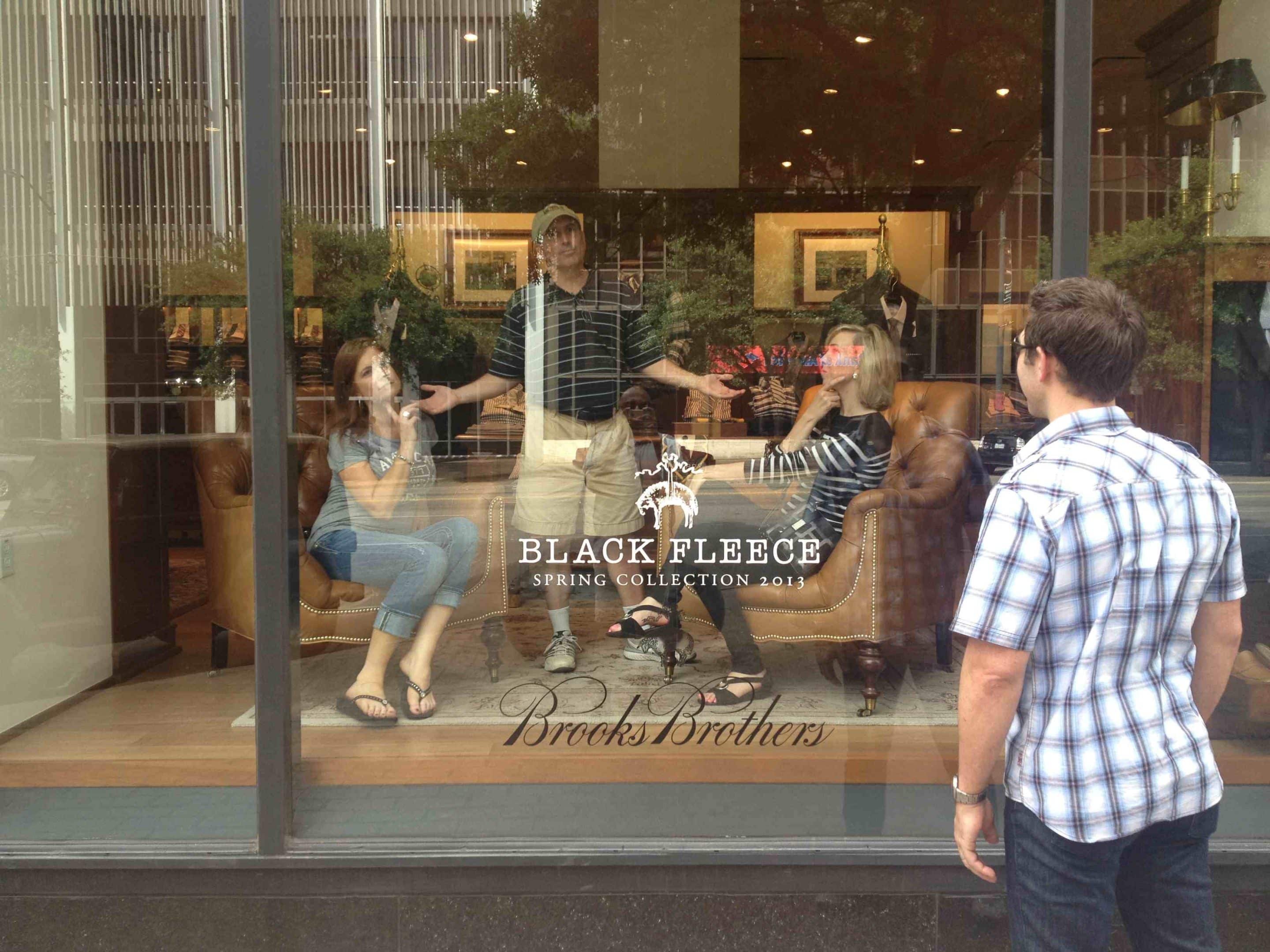 Scavenger hunters pose like dummies in a store window.