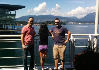 3 team members standing with a big lake as their backdrop during a team building activity in Vancouver.