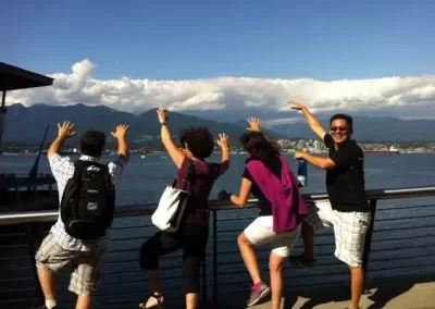 A scavenger hunt team looking at a lake with their hands up.