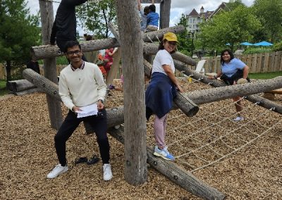 During a team-building activity 4 team members are climbing on a wooden structure in a park.