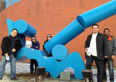 5 team members taking a photo with a giant structure during a team building activity in Edmonton.