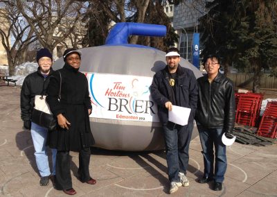 4 team members taking a photo with a giant ball during a team building activity in Edmonton.