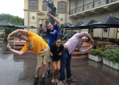 4 team members standing together with their hands raised and one in the middle during a team building activity in Kansas City.