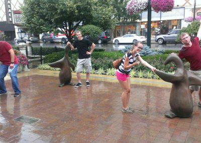 A team of 4 members taking photo with penguin sculptures during the Kansas City Scavenger Hunt.