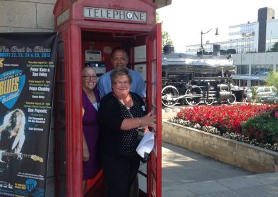 3 team members takes a photo inside a red telephone booth during the Kingston Scavenger Hunt.