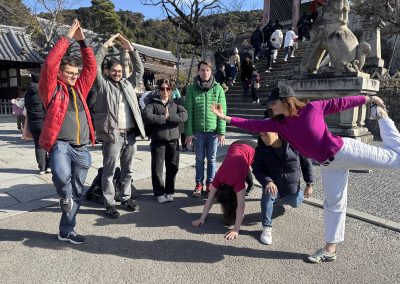 Scavenger hunt team members doing yoga pose next to a tiger statue.