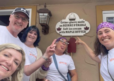 5 team members taking a photo with a sign during the Mont Tremblant Scavenger Hunt.
