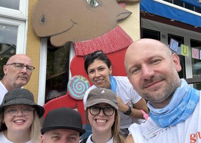 6 team members taking a selfie with a giant cartoon moose during a team building activity in Mont Tremblant.