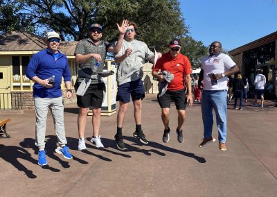 A scavenger hunt team of 5 jumping during a team building activity in Orlando.