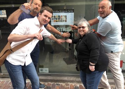 4 scavenger hunt team members covering up a clue with their hands
