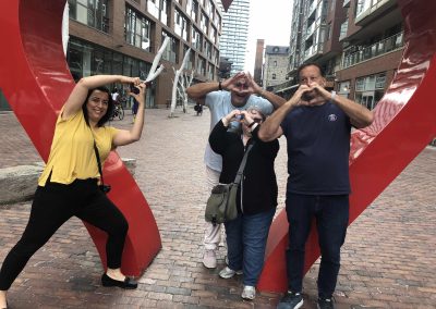 4 team members making hearts with their hands during a team building activity in Toronto Distillery District.