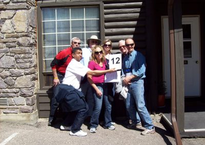 Scavenger hunt team members are standing together, with one on the far left holding a number card.
