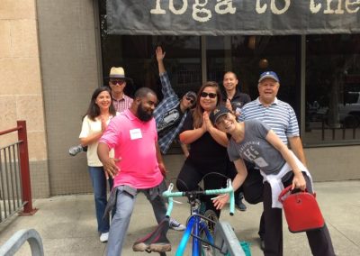 A group of eight people doing some stretching while looking at the camera during a team building activity in Berkeley.