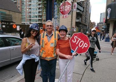 Three scavenger hunt team members stand together, with one holding a stop sign