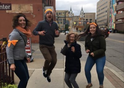 Scavenger hunt team members jumping on a street