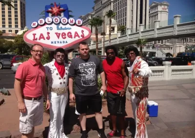 3 team members taking a photo with two Elvis in Las Vegas
