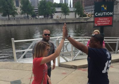 Two team members doing a high 5 and 2 at the back staring at them