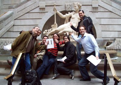 A group of eight people taking a photo with a sculpture