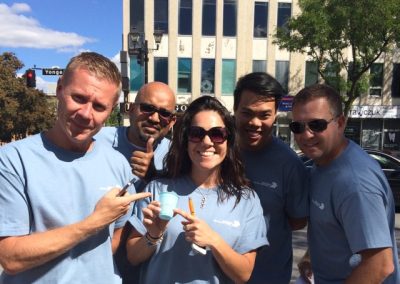 A team of four gathers, with one member in the center holding a cup, as the others point towards it during a team building activity in Richmond Hill.
