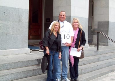 Three people standing and smiling during a team building activity in Sacramento.