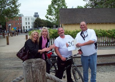 A group of four individuals taking photo with a bike during the Sacramento Scavenger Hunt!