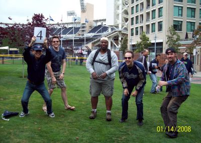 A team of five members standing on a field about to jump during a team building activity in San Diego.