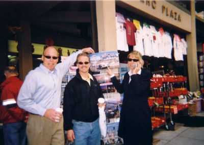 Three people taking a photo with their shades on and pointing to a picture behind them during a team building activity in San Francisco.