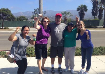 5 people holding their hands up and smiling during a team building activity in Santa Barbara.