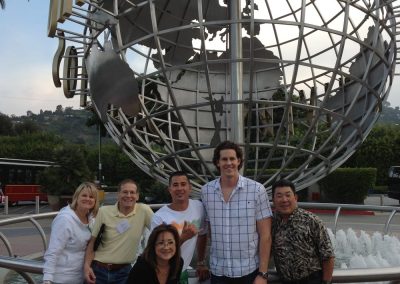 A group of 6 stands beneath a giant globe during a team building activity in Universal CityWalk Hollywood.