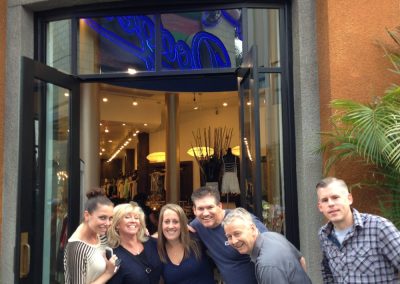 A team of 6 standing in front of a building looking at the camera smiling during a team building activity in Universal CityWalk Hollywood.