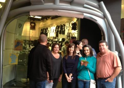 A scavenger hunt team of six stands within a massive Raiders helmet.