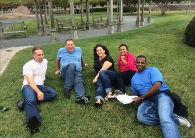 5 scavenger hunt team members laying on grass.