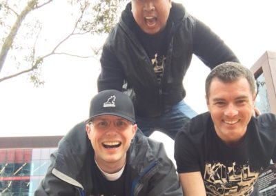 3 team members making a pyramid, 2 at the bottom and 1 at the top during a team building activity in Darling Harbour.