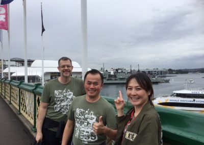 Scavenger hunt team members of 3 take a photo in a harbor.