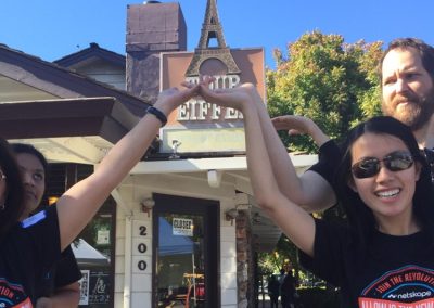 3 team members raise their hands up during a team building activity in Los Altos