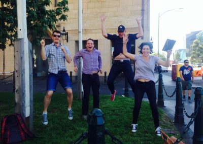 Scavenger hunt team members jumping on a lawn.