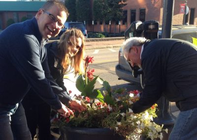 3 team members looking for a clue in a large pot during the Moncton Scavenger Hunt.