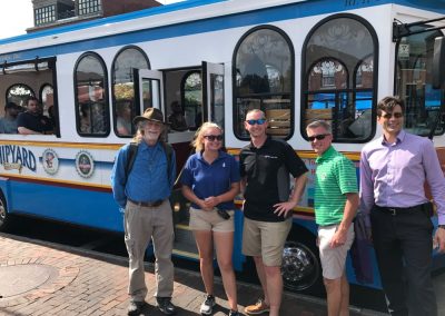 5 team members standing in front of a Tram during a team building activity in Portland ME