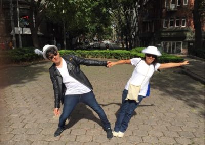 2 scavenger hunt team members holding each other's hands while leaning the opposite way.