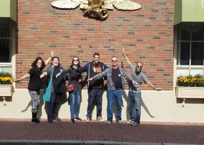 6 team members stands in front of a brick wall during a team building activity in Salem.