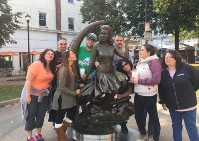 Scavenger hunt team takes a photo with a statue in Salem,