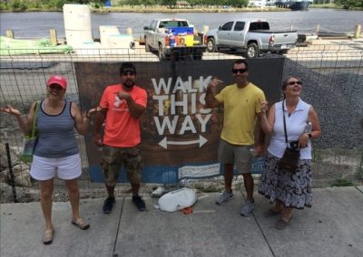 4 scavenger hunt team members stands in front of a sign.